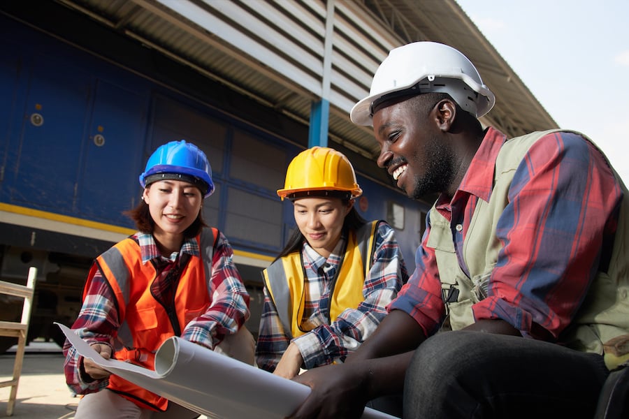 3 construction workers looking at a technical drawing